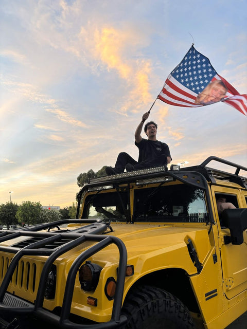 Custom face flag waved from the roof of a yellow Hummer at sunset