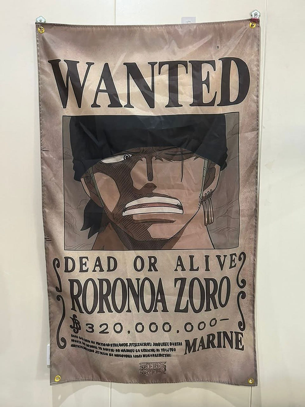 Zoro wanted poster flag hanging on a wall with corner grommets